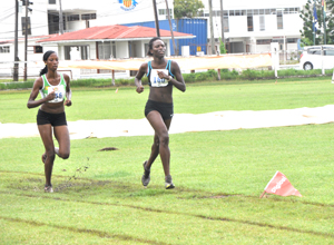 3,000 metres winner Alika Morgan leads Grenada?s Kenisha Pascal in the final lap yesterday at the Police Sports Club ground.