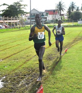 Eventual winner of the Men?s 5,000 metres Cleveland Forde about to pass runner-up Nathaniel Giddings en route to victory yesterday.