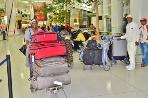 This Guyanese, who has not had a Guyanese Christmas in 18 years, drove eight hours from Ohio, is seen pushing her baggage cart to “line up in faith” having already spent two days at the airport.