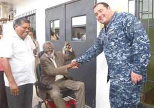Lieutenant Commander Robert Novotny, Commander U.S. Military Liaison Office handing over the keys to the building to Dr. Roger Luncheon. 