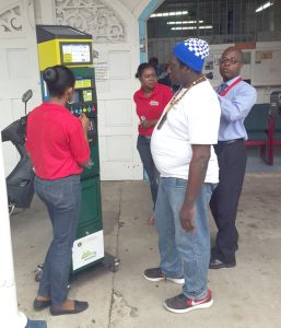 An employee demonstrates use of parking meter to a concerned citizen