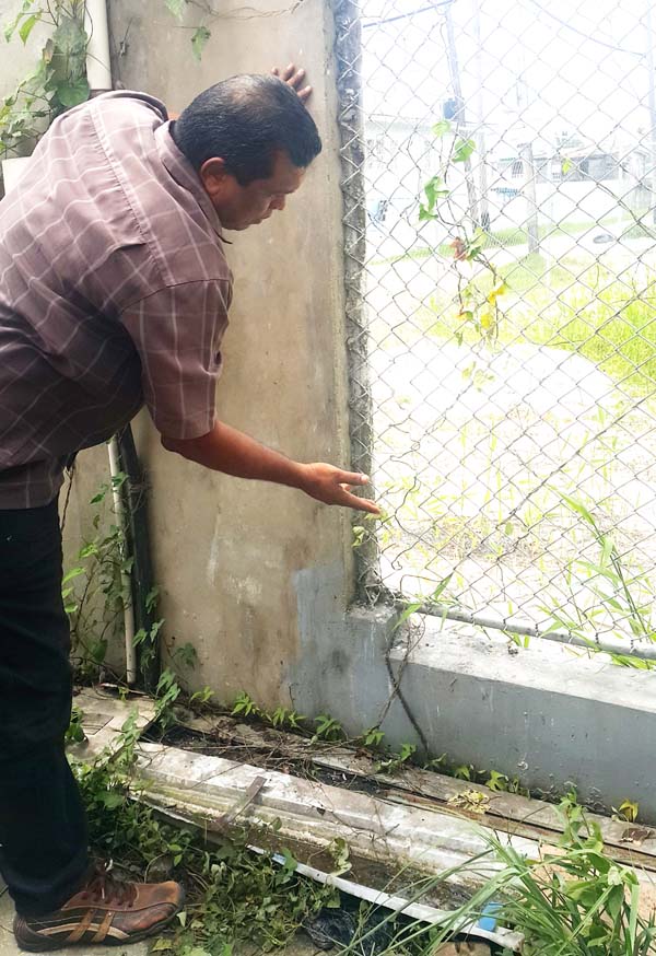 Mahendra Mookram pointing to where the men entered the compound.
