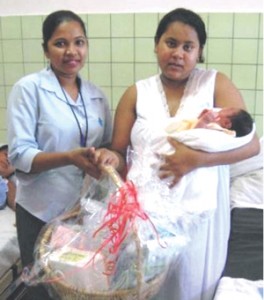Yashoda Prashad receives her RightStart Baby Care Hamper and letter from Ms.  Kunti Rampersaud, Administrative Assistant, Anna Regina Branch at the Suddie Hospital