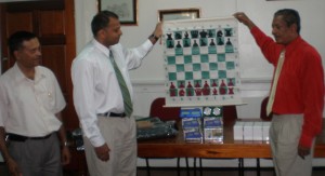 President of the Guyana Chess Federation Errol Tiwari  (right) displays one of the Demonstration Boards with Minister  Dr. Frank Anthony, while Shiv Nandalall (left) looks on.