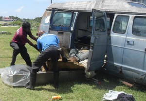 Undertakers remove the body from the abandoned vehicle.