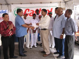  Guyoil’s Leonard Khan (5th right) hands over the  sponsorship cheque to GCB President Chetram Singh while  other GCB executives and members of the East Coast under-15 team  share the moment yesterday at the Guyoil Gas Station on Regent Street. 