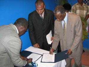  President of the American University of Peace Studies,  Dr Eton Simon (right) and Executive Director of GWTV Channel 2,  Godfrey Washington (left) sign the MOU forming GEN 2. 