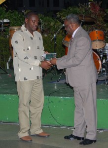Franklin Wilson (left) receives his  award from GOAs Ivor O’Brien