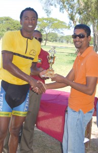 Henry Rambarran Jr. (right) hands over the  winning trophy and cash to Warren Mc Kay