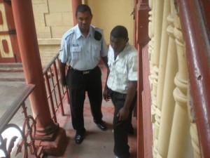 Jamal Edi, right, is escorted from the lock-ups