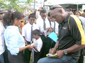 Sir Vivian Richards (right) signs autographs yesterday on Main Street as part of the Johnnie Walker ‘Know Your Boundaries’ campaign.