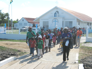 Members of the congregation leaving the church yard yesterday as they begun their procession around BV. 