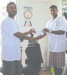 Manager of Universal Sports Complex Steve Mangal  (left) hands over the airline ticket to Avinash Persaud.