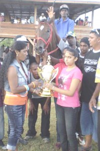 Miss Aneela Kirtipaul (right) presents the winning trophy in the C class event to Miss Sukhoo of the Rooney stable. 