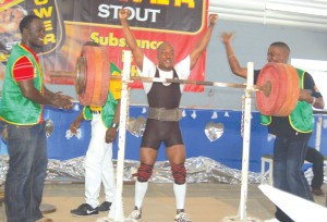 Kester Lewis raises his hands in celebration after  setting a new squat record in the 67.5kg – 148.5lbs category. 