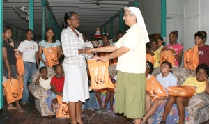 Republic Bank’s Communications and Public Relations Officer (ag) Jonelle Dummett (left), presents the shoes to Sr. Beatrice Fernandes of the St. Ann’s Orphanage.