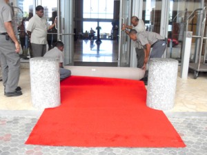 The red carpet being rolled out at the Hyatt Regency Hotel yesterday as preparations move apace for the Summit of the Americas