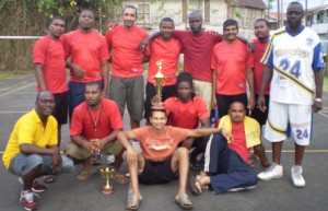 A victorious Rollers Volleyball club pose with  their silverware.  Charles Henry stands at right.