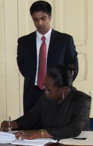 Town Clerk (ag) Yonette Pluck-Cort inks the MOU in the presence of Polaris Assistant Vice President, Vikram Aligh
