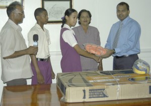 Sport Minister Dr, Frank Anthony (R) hands over the equipment to President’s College student Gina Chin. 