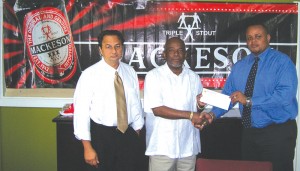 Stanford Soloman (centre) collects the check from Ansa McAl Marketing  Director, Troy Cadogan (right) while President of the Guyana Boxing  Board of Control, Peter Abdool witnesses the occasion.