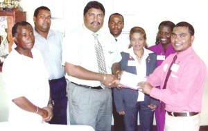 Mohamed Azim of the Bank of Nova Scotia hands over the sponsorship Cheque to Berbice Cricket Board Treasurer Anil Beharry in the presence of President, Keith Foster, 3rd Vice President, Richardo Bachan and Staff members of the Bank, New Amsterdam Branch.
