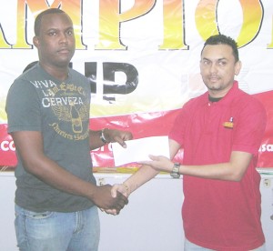 Edward B Beharry Company Limited’s Area Manager, Harry Shewpaltan (right) hands over the sponsorship cheque to Next Level Entertainment’s, Jamaal Douglas.