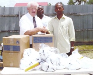 Elder Vincent Whitehead (left) presents football and other kits to BFA President Keith O’Jeer.