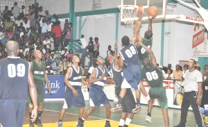 CAN’T STOP ME!!! Royston Siland (with ball) towers above Darcel Harris (#8) on his way to the basket.