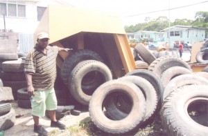 Businessman Tony Rutherford points to some of the allegedly used and damaged tyres before they were removed on Friday. 