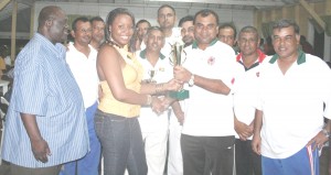 A female representative hands the winning trophy on behalf of Comissioner of Police Henry Green (left) to Floodlight Skipper Ricky Deonaraie.