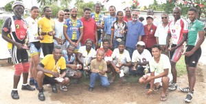 Top performers row!!! The Top performers at the Annual Ballot Box Martyrs’ cycle road race pose with Dr. Frank Anthony (centre) and other high ranking officials of the PPP at the Memorial site of the Ballot Box Martyrs’, No. 63 Village. (Franklin Wilson photo) 