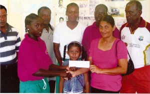 Diane Lewis (right) hands over sponsorship cheque to Shermaine Campbell, Berbice female cricket captain, in the presence of Board members and others.