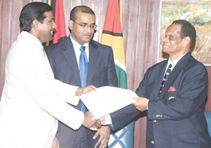WIPA President Dinanath Ramnarine (left) and Dr. Julian Hunte, WICB President, shake hands to signify the completion of the agreement between the two parties, as President and CARICOM Chairman Bharrat Jagdeo (centre) looks on.