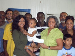 Remembering the less fortunate: Gem Madhoo-Nascimento hands over a cheque to Varshnie Singh, Head of the Kids First Fund as cast members of Link Show 25 look on along with some of the children and parents who benefited from the most recent hearts surgeries in India.  