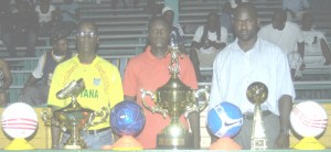 Organisers of the East Coast Demerara Cup Knockout Football Tournament (from left) Mark Phillips, Calvin Marks and Lynton Luke pose with the trophies and prizes last Monday evening, at the Cliff Anderson Sports Hall. 