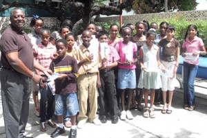 Banks DIH’s Marketing Director George Mc Donald yesterday distributed the bursaries to a group of smiling recipients 