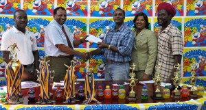 Manager Guyana Beverage Inc. Robert Selman (2nd left) hands over the  sponsorship cheque to First Vice President of the GFA Wayne Forde in the presence  of, from left, GFA Secretary Marlan Cole, Shameeza Yadram and Sampson Gilbert. 