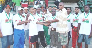 Captain of Dyna’s Bravados Joshua Lakhan (left) receives the winner’s trophy from tournament coordinator Rodnew McDonald.