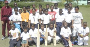 Barbadian Female Cricket Coach Richard Clarke  (extreme left) poses with Sports Organiser Allister Munroe  (back row second left) and junior windball cricketers last Thursday.   