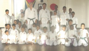Standing in Centre Sensei Amir Khouri along with Sho Dan awardees (from left) Bhoindra Prashad, Leah Shariff and Ryan Amir with the other students who received their colored belts certificates. Absent are Althia King and Patrick Cheeks.