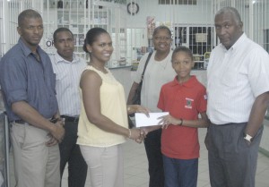  Manager of Medicine Chest Jackie McDonald-Fraser  (third left) hands over the cheque to Chelsea Edghill in the  presents of her parents and officials of the GTTA yesterday.