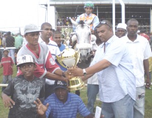 Mr Kris Jagdeo at right receives the winning trophy in the 3 year old race.