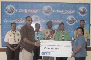 Vice President of the Guyana Scout Association, Ramsay Ali, receiving the cheque from GT&T Marketing Officer, Ms. Abena Fung, in the presence of other members of the Association. 