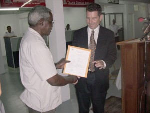 Minister of Transport and Hydraulics Robeson Benn  (left) presents the International certificate to the Chairman  of the Board of Directors Michael Correia 