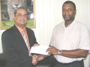 Minister Prashad (left) receives the cheque from Wystan Robertson 