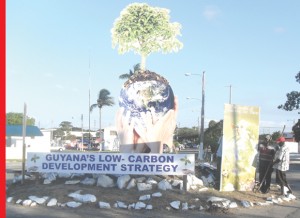 Putting up the painted tree: Workmen seen at the roundabout island in the Sophia Exhibition Site putting up pictorials in keeping with the Guyana Low Carbon Development Strategy theme yesterday. 