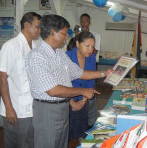 Senior Education Minister Shaik Baksh (centre) examines a literacy publication in the company of Minister within the Education Ministry, Dr Desrey Fox, and NCERD Director, Mohandatt Goolsorran.