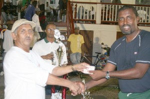 Ramchand Ragbeer hands over the $60,000 cash donation to  President of DCC Alfred Mentore on behalf of Floodlights
