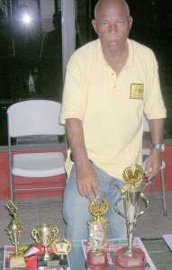 Organiser Johnny ‘Overseas’ Barnwell poses with the trophies for the winning teams yesterday. 